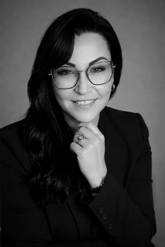 Joanna z Aisa Design Kobieta z dłonią pod brodą, uśmiechnięta ekspertka od WordPress